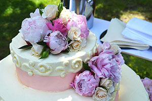 White and pink cake decorated with multiple flowers
